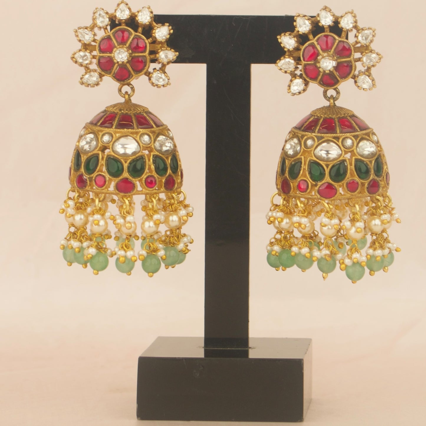 Jhumka earrings pair in gold tone with red and green stones and pearl fringe