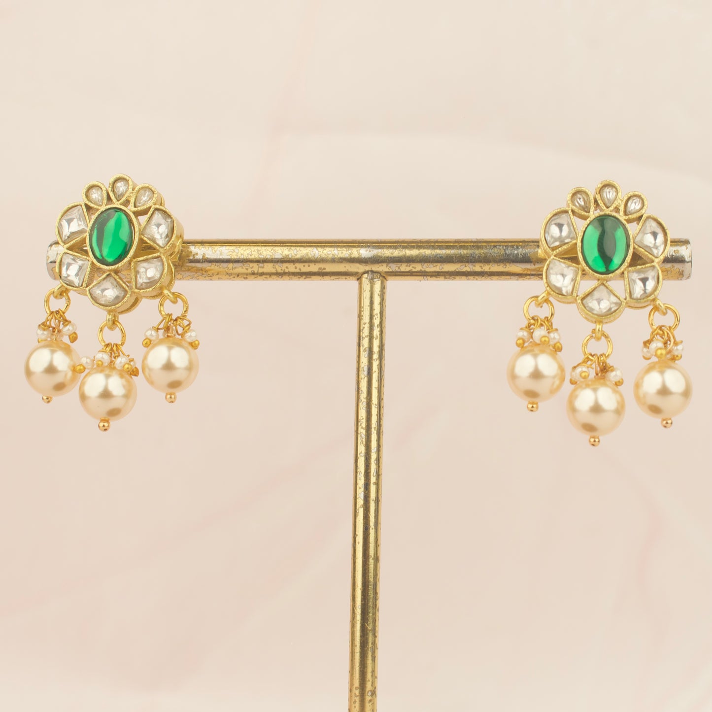 Pair of jadau kundan earrings with emerald green centers and pearl drop clusters