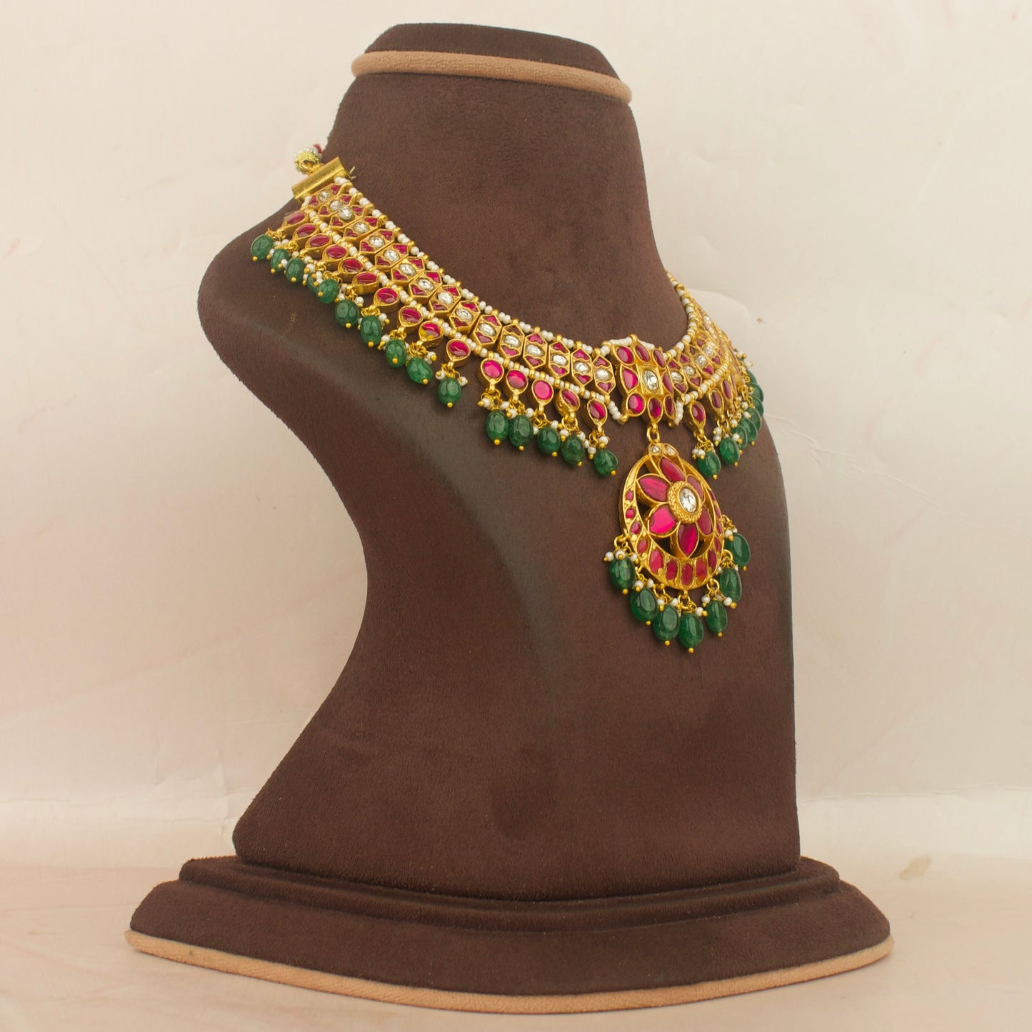Kundan jadau choker necklace with green beads hanging on display bust