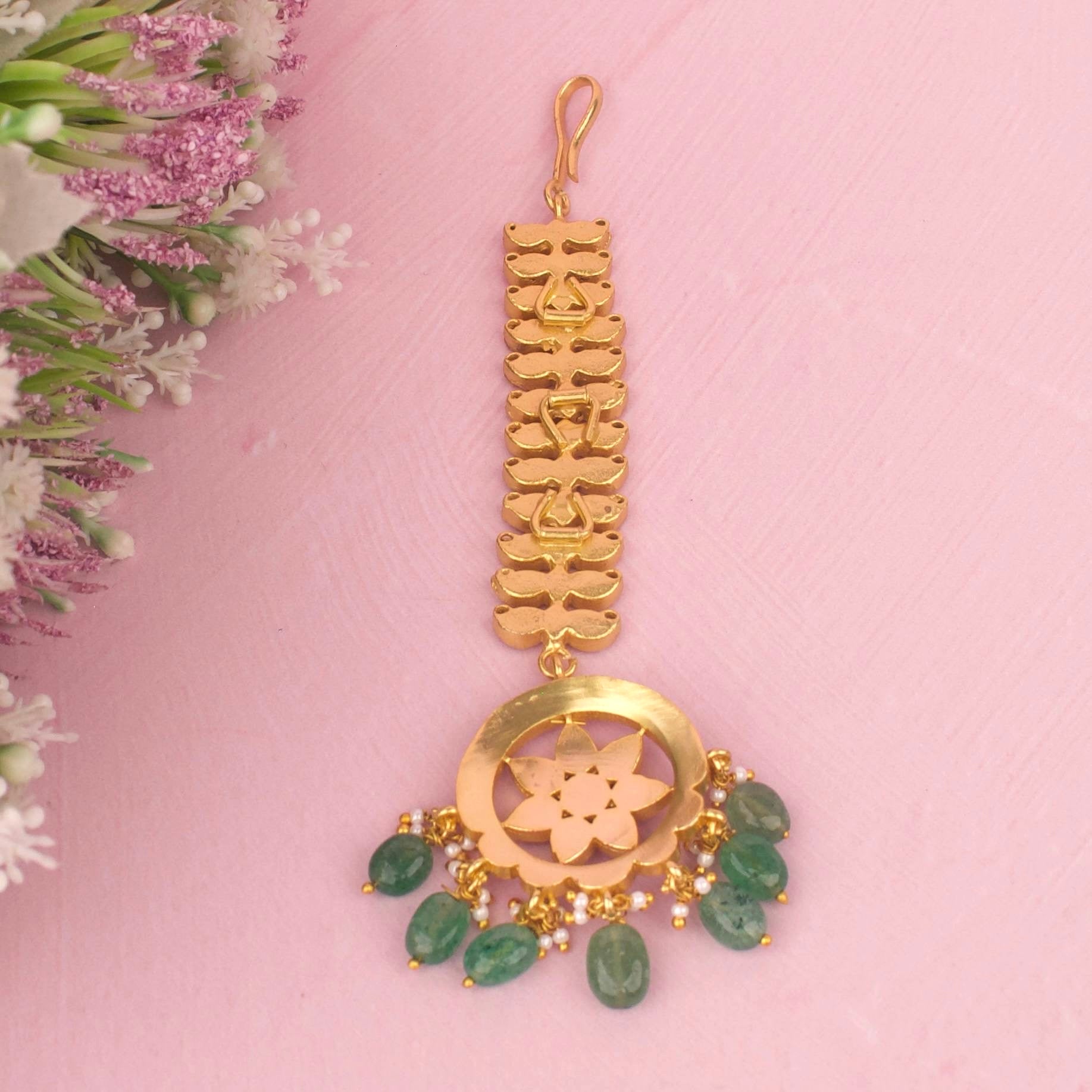 Close-up detailing of Floral Jadau Kundan Maang Tikka With Emerald Beads adorned with ruby