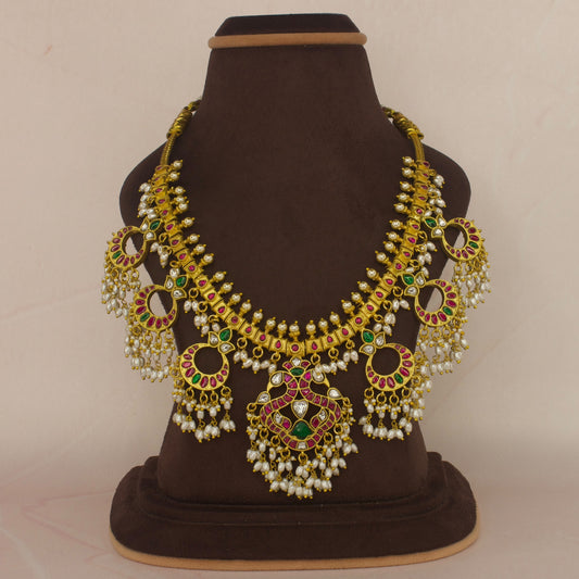 This is a Jadau Kundan Guttapusulu Necklace with Rice Pearls Guttapusalu. This piece has Peacock motifs on it with 22k Gold plating