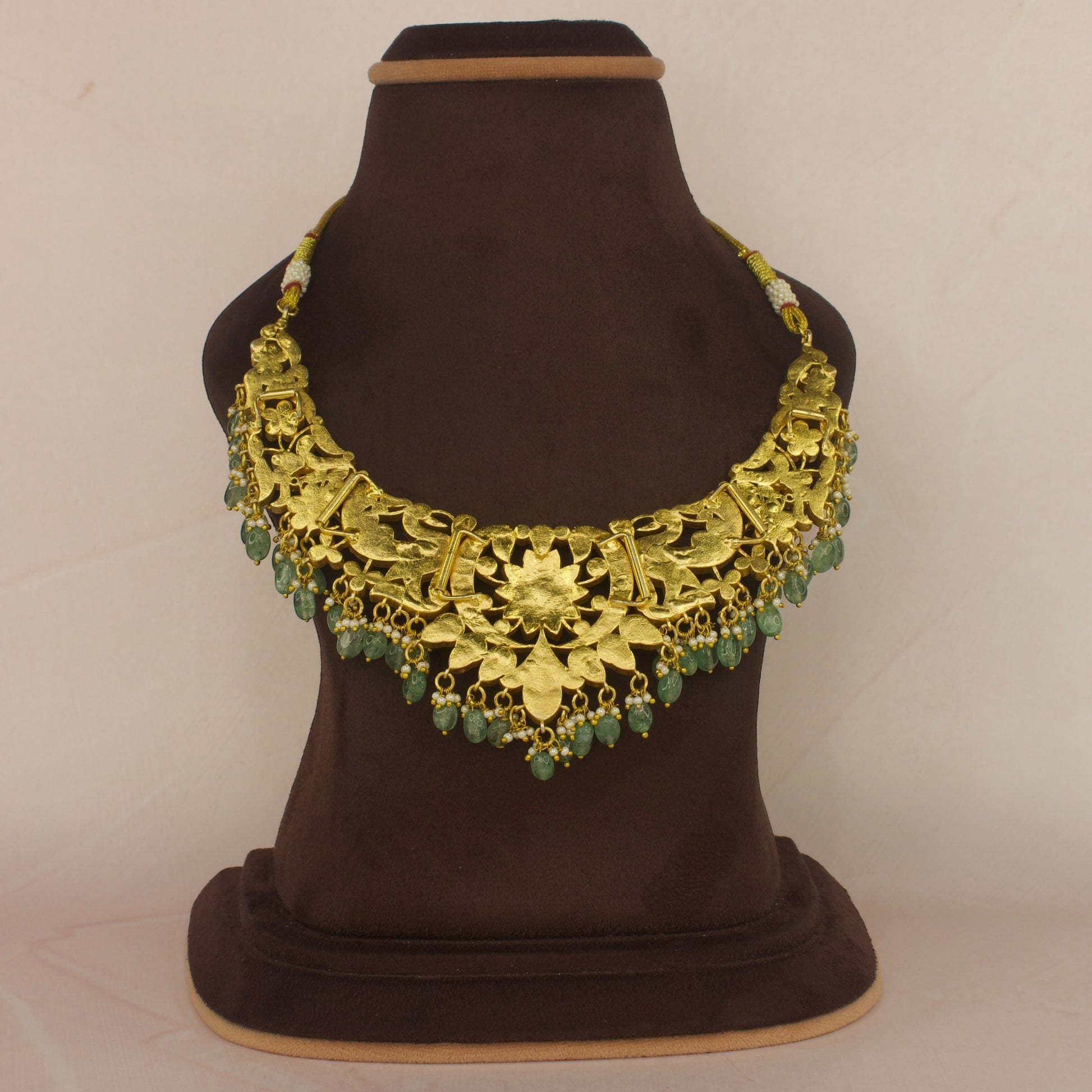 This Necklace is 22k Gold plated. It has floral motifs all over it and at the bottom of the necklace we have Russian emerald beads