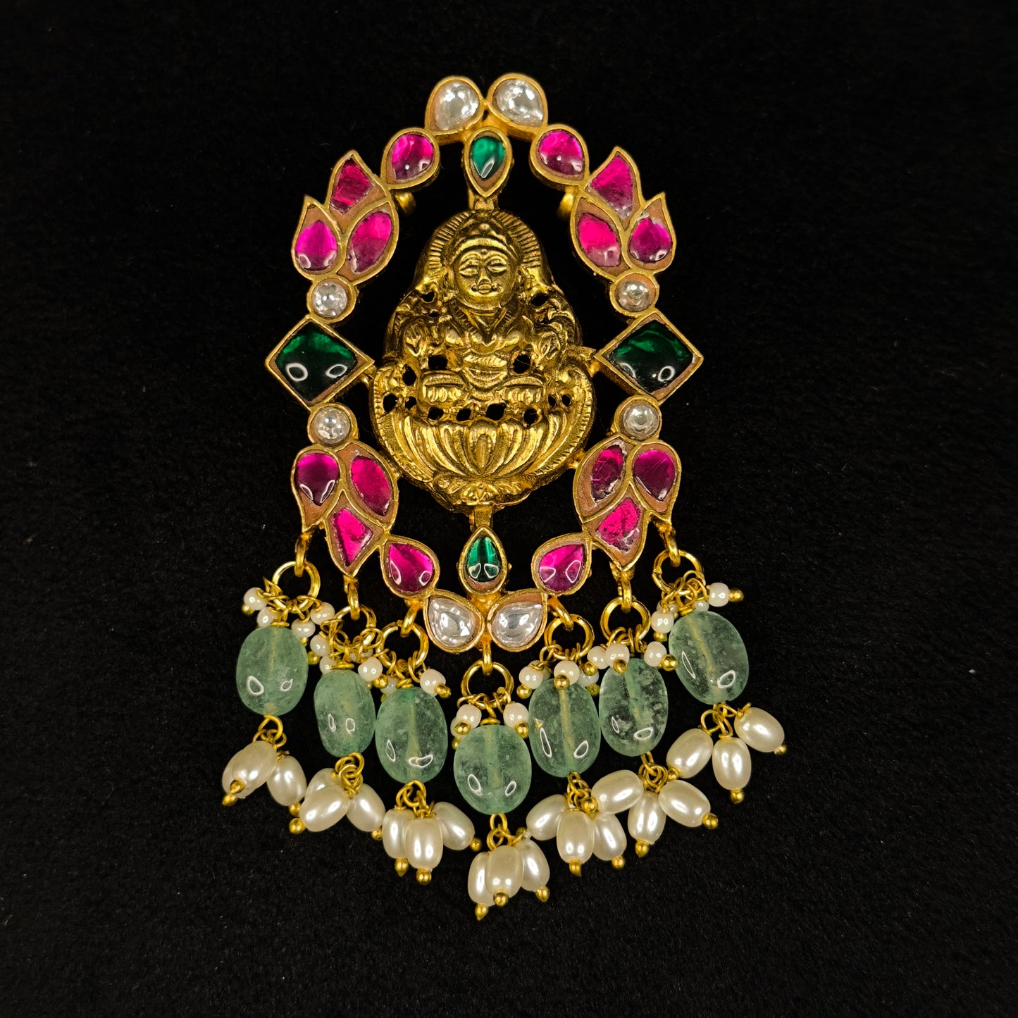 Divine jadau Kundan pendant with Goddess Lakshmi motifs . The pendant is covered with 22k gold plating. At the bottom of pendant we have Swarovski pearls and Russian emerald beads