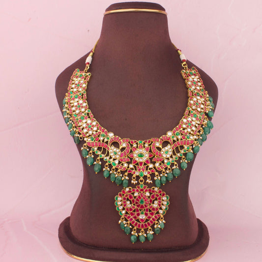 Premium Jadau Kundan Necklace With Ruby Stone Detailing, Emerald Bead Hanging And Floral Peacock Design With Pendant