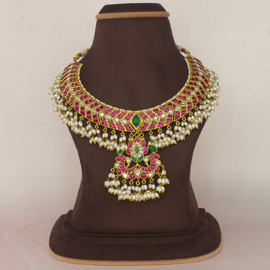 This is a Guttapusalu Jadau Kundan Short Necklace with Rice Pearls in Multi colour. This piece is covered with 22k gold plating and at the bottom of the necklace we have added ricepearls