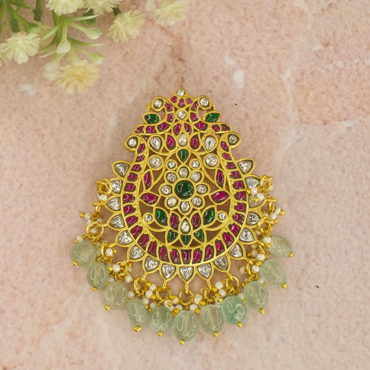 This is a Jadau Kundan pendant with 2 majestic peacocks and Flower in the centre design. It’s covered with 22k gold plating and at bottom of it we have Russian strawberry beads