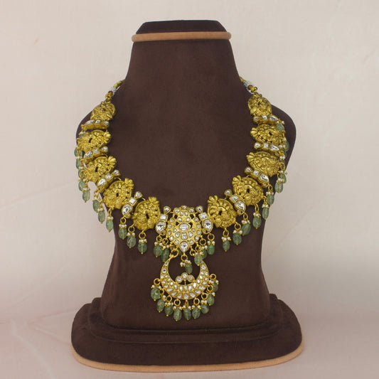 This is a Jadau Kundan Short necklace in White kundan stones. The peacock motifs on the pendant are in nakshi finish. The whole piece is covered in 22k gold plating and at the bottom of the necklace there are Russian strawberry Beads