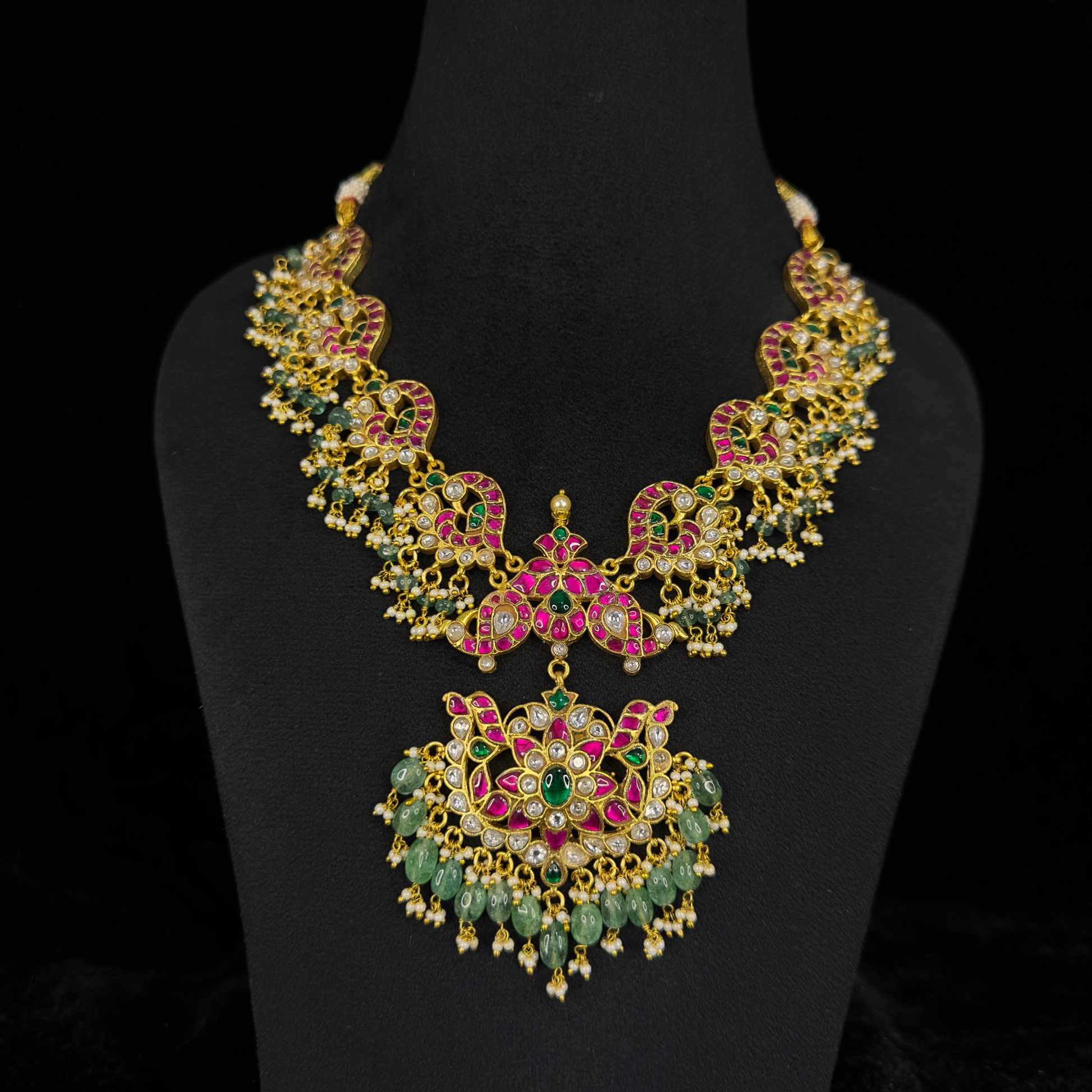 Radiant Peacock Motif Jadau Kundan Necklace with Emerald Drops with 22k gold plating. This product belongs to jadau kundan jewellery category