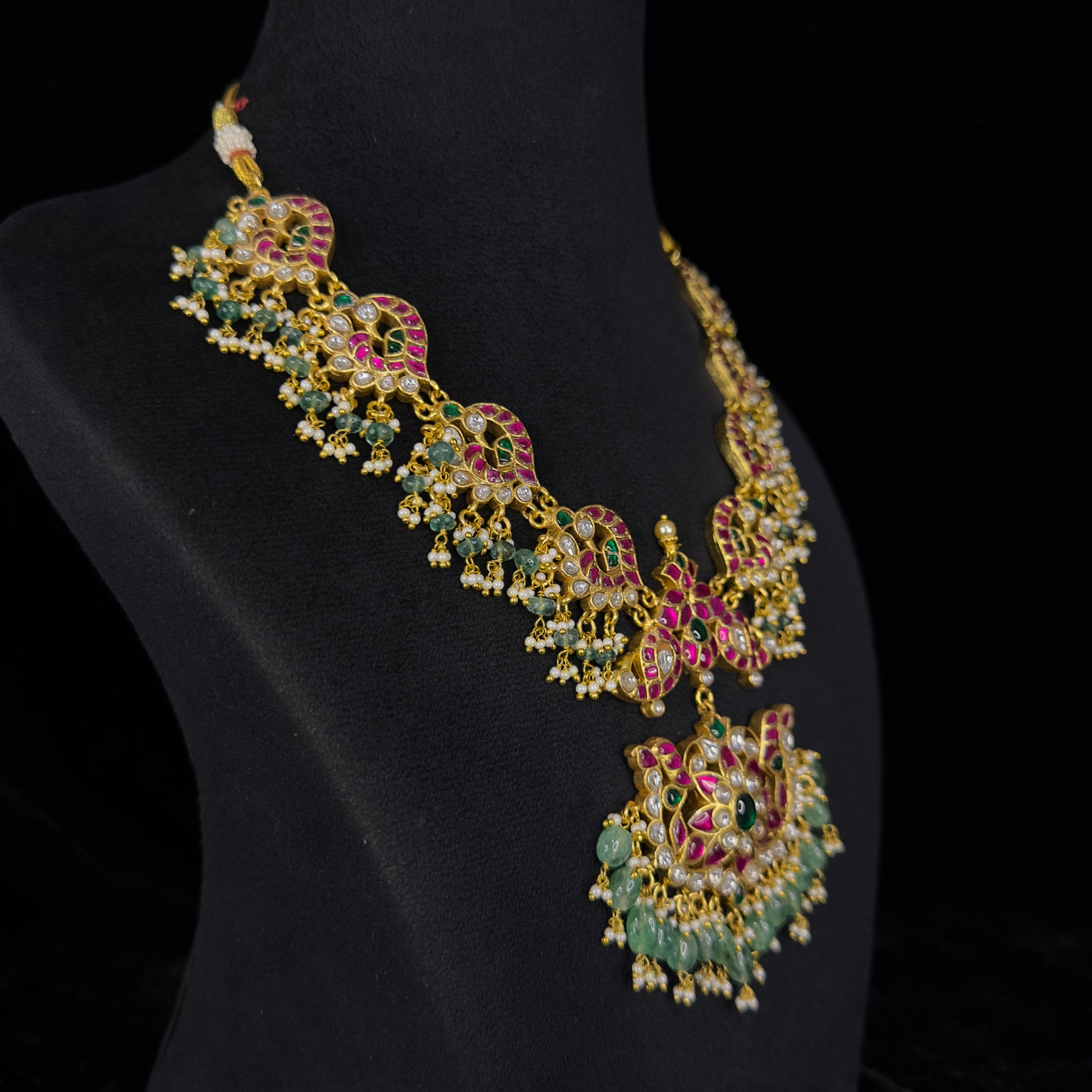 Radiant Peacock Motif Jadau Kundan Necklace with Emerald Drops with 22k gold plating. This product belongs to jadau kundan jewellery category