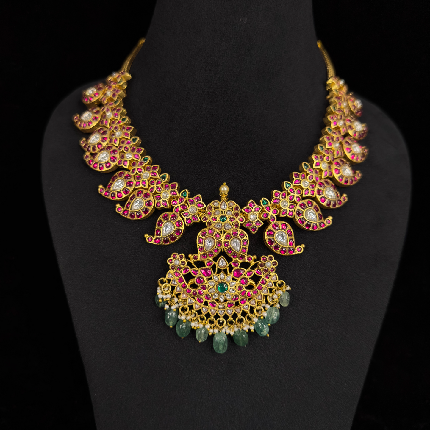 Opulent Mango Jadau Kundan Necklace with Intricate Floral Motifs and Emerald Drops with 22k gold plating This product belongs to Jadau Kundan jewellery category 