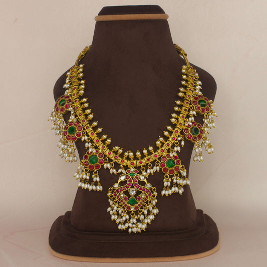 This is a Jadau Kundan Rice pearl Guttapusalu necklace with Peacock and Flower motifs. It’s covered in 22k Gold plating