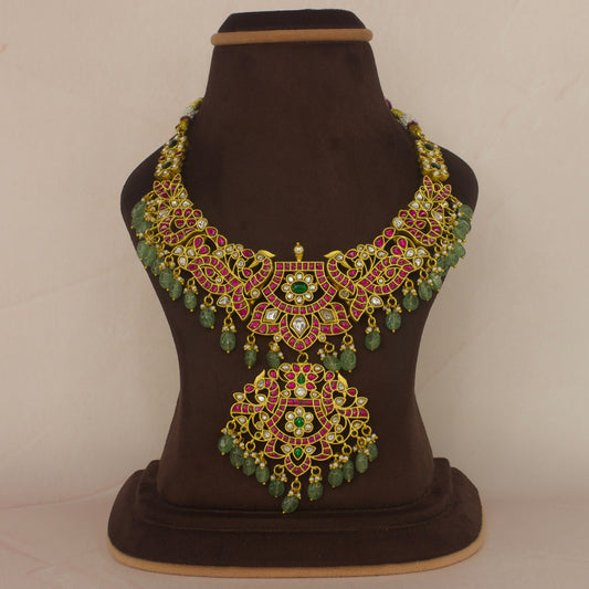 This is a jadau Kundan short necklace with flower motifs. This piece is covered with 22k Gold plating and at the bottom of the piece we have added Russian green beads with pearls