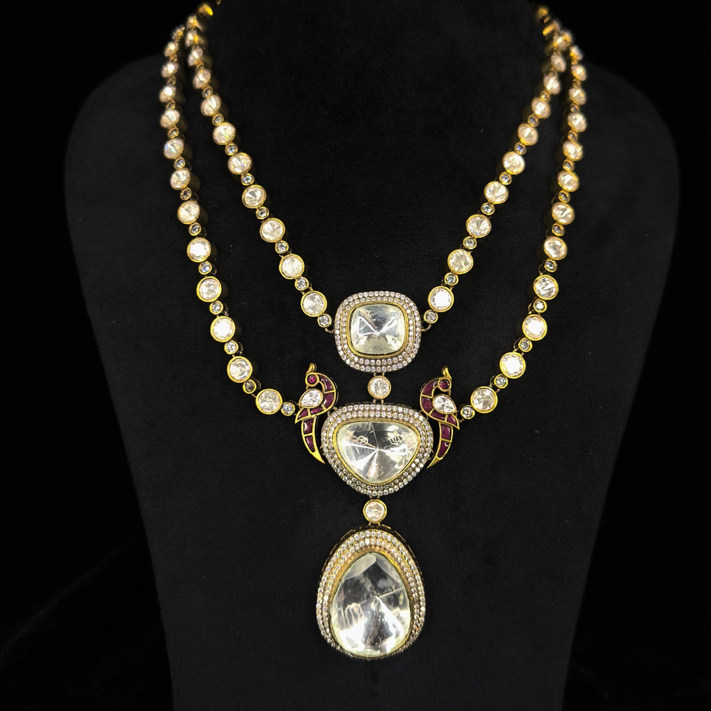 Two-Step Voguish Victorian Necklace Set with peacock motifs, zircon, moissanite polki stones, pearls, and beads, including matching earrings. This Victorian Jewellery is available in a White colour variant. 