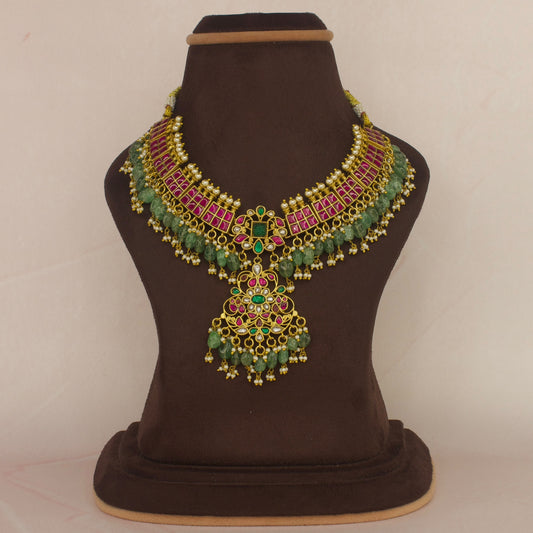 This is a jadau Kundan short necklace with intricate designs, this piece is covered with 22k Gold plating and at the bottom of piece we have Russian emeralds
