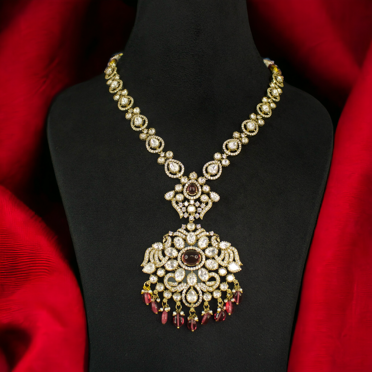 Antique Victorian Necklace Set in Ruby colour with zircon, moissanite polki stones, peacock motif, pearls, and beads. This Victorian Jewellery is available in a Red colour variant. 