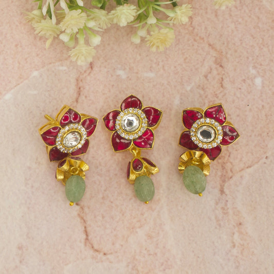 This is A Small sized jadau Kundan pendant set. The pendant and earrings are shaped in flower design. Available in 2 colour variants Red and Green