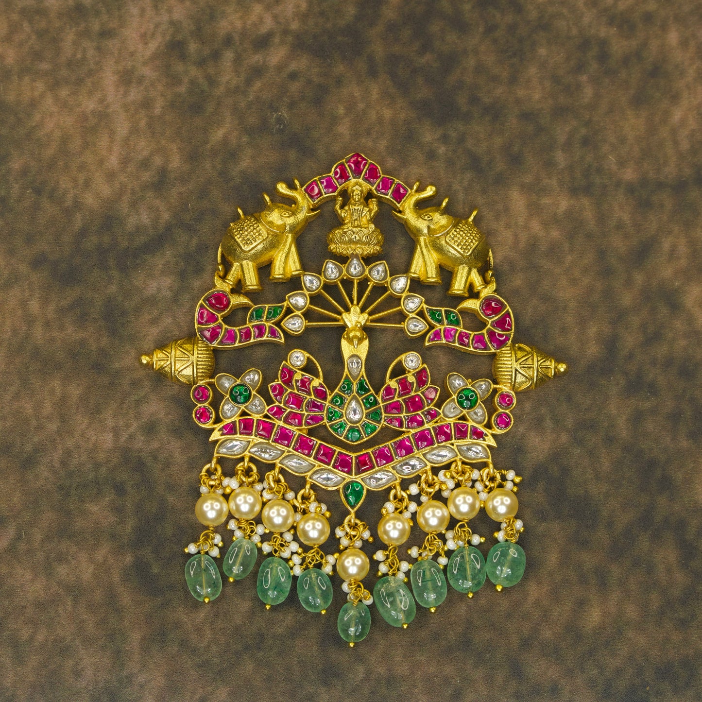 Handcrafted Jadau Kundan Pendant, with uncut Ruby and Emerald gemstones, pearls, beads, elephant & peacock motifs, in a 22k gold plating. 