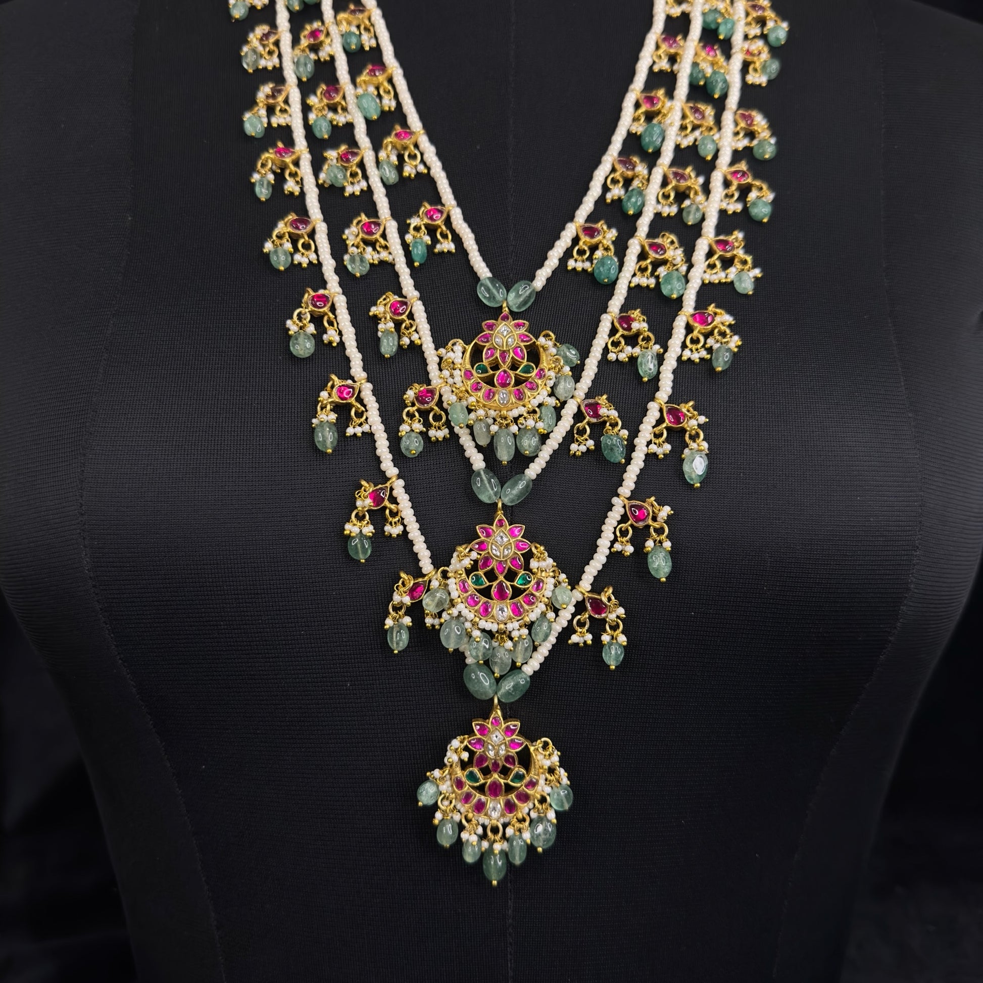 Opulent Jadau Kundan Multi-Layered Necklace with Emerald Drops with 22k gold plating . this product belongs to jadau kundan jewellery category