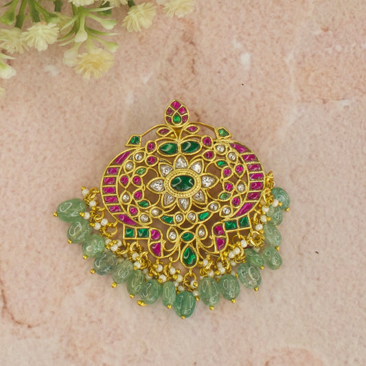 Here is Our Jadau Kundan pendant With motifs of 2 Peacocks with a Flower in the middle. This is 22k Gold plated pendant with Russian emerald beads at bottom