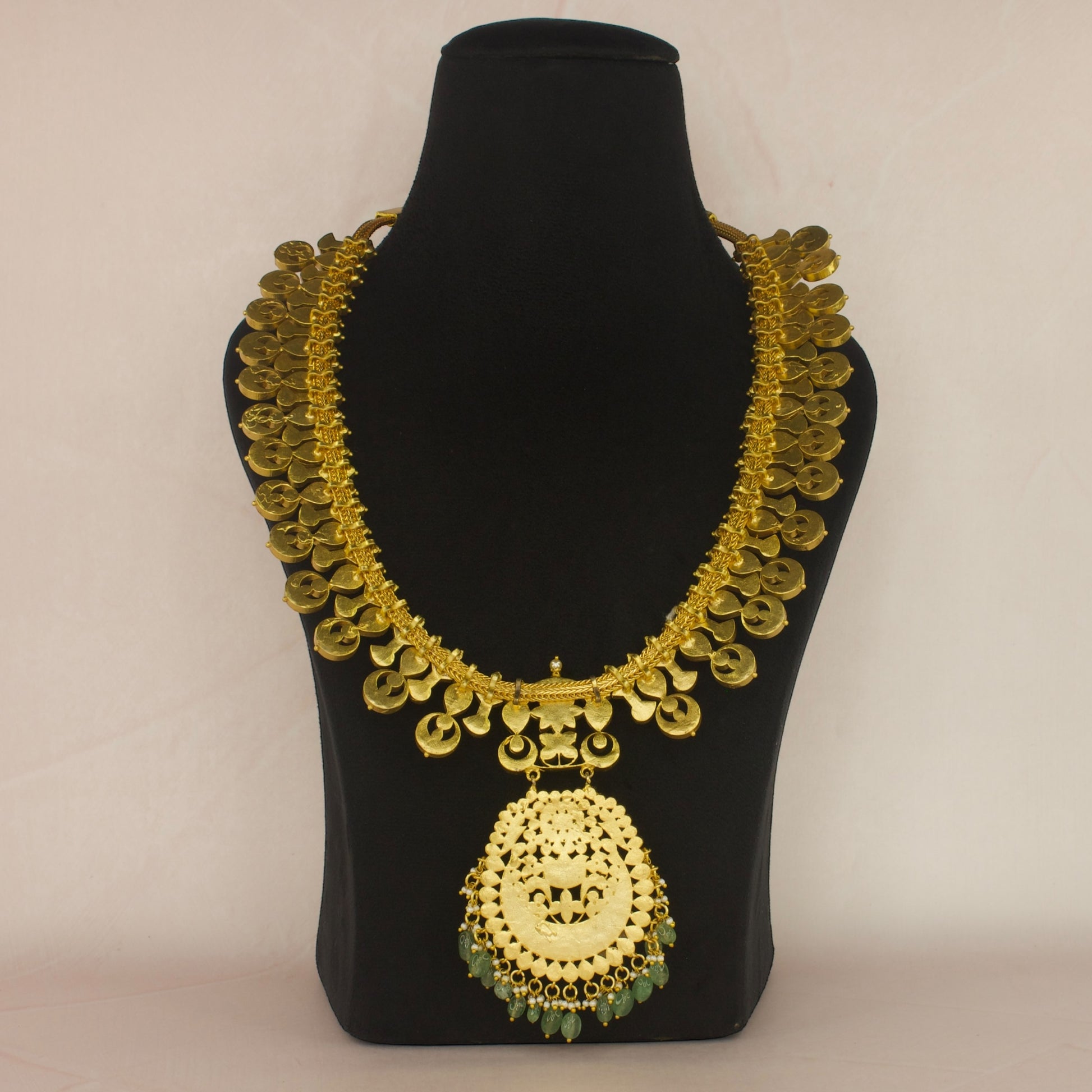 This is a Jadau Kundan Necklace with 22k Gold plating . This necklace has flower motifs and Russian emeralds at bottom