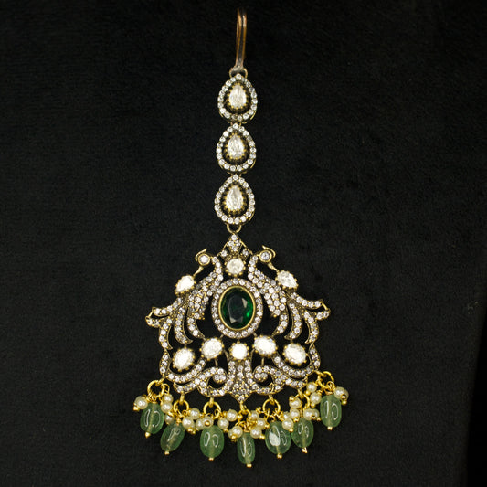 Traditional Antique gold Victorian finish Maang Tikka with bead drops. This Victorian Jewellery Is available in Red & Green colour varaiants. 