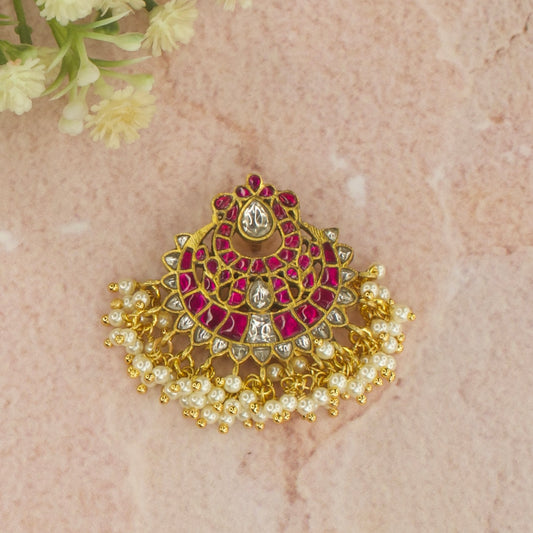 This is a jadau Kundan pendant in ruby and white colour. It is covered in 22 k gold plating with pearls 
